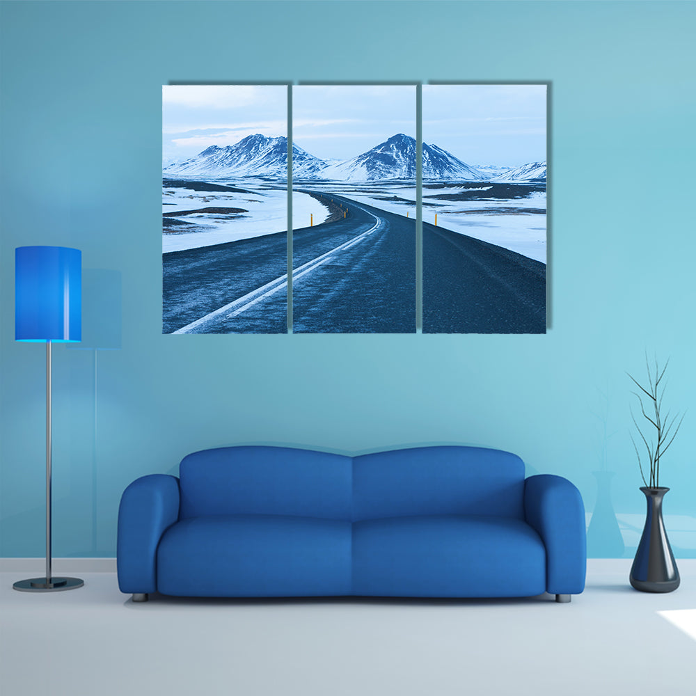 The road at twilight through the snow capped mountains in winter multi panel canvas wall art