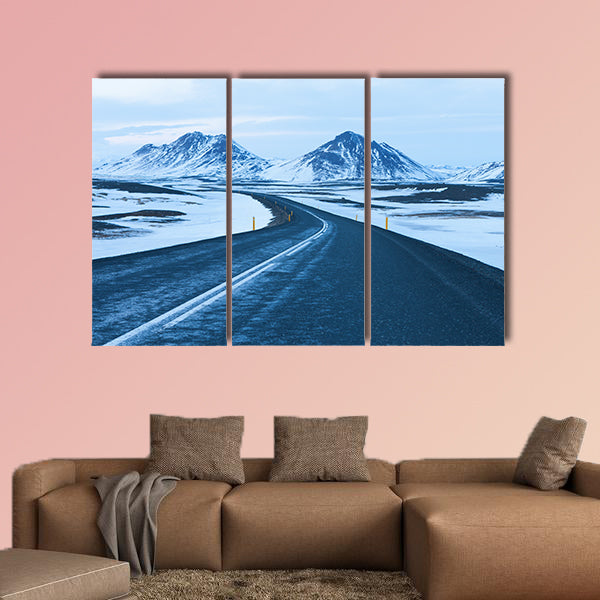 The road at twilight through the snow capped mountains canvas wall art