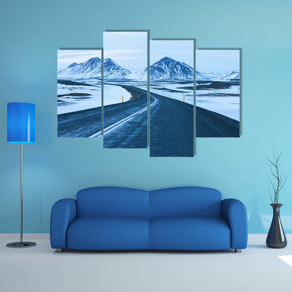 The road at twilight through the snow capped mountains in winter multi panel canvas wall art