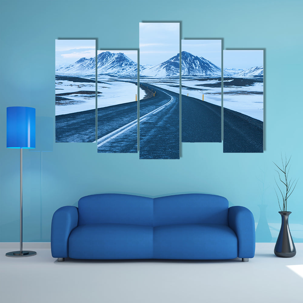 The road at twilight through the snow capped mountains in winter multi panel canvas wall art