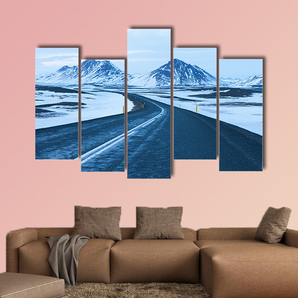 The road at twilight through the snow capped mountains canvas wall art