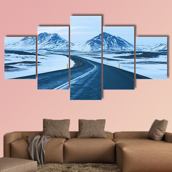 The road at twilight through the snow capped mountains canvas wall art