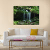 A small water fall flows on a rock ledge Multi Panel Canvas Wall Art