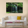 A small water fall flows on a rock ledge Multi Panel Canvas Wall Art