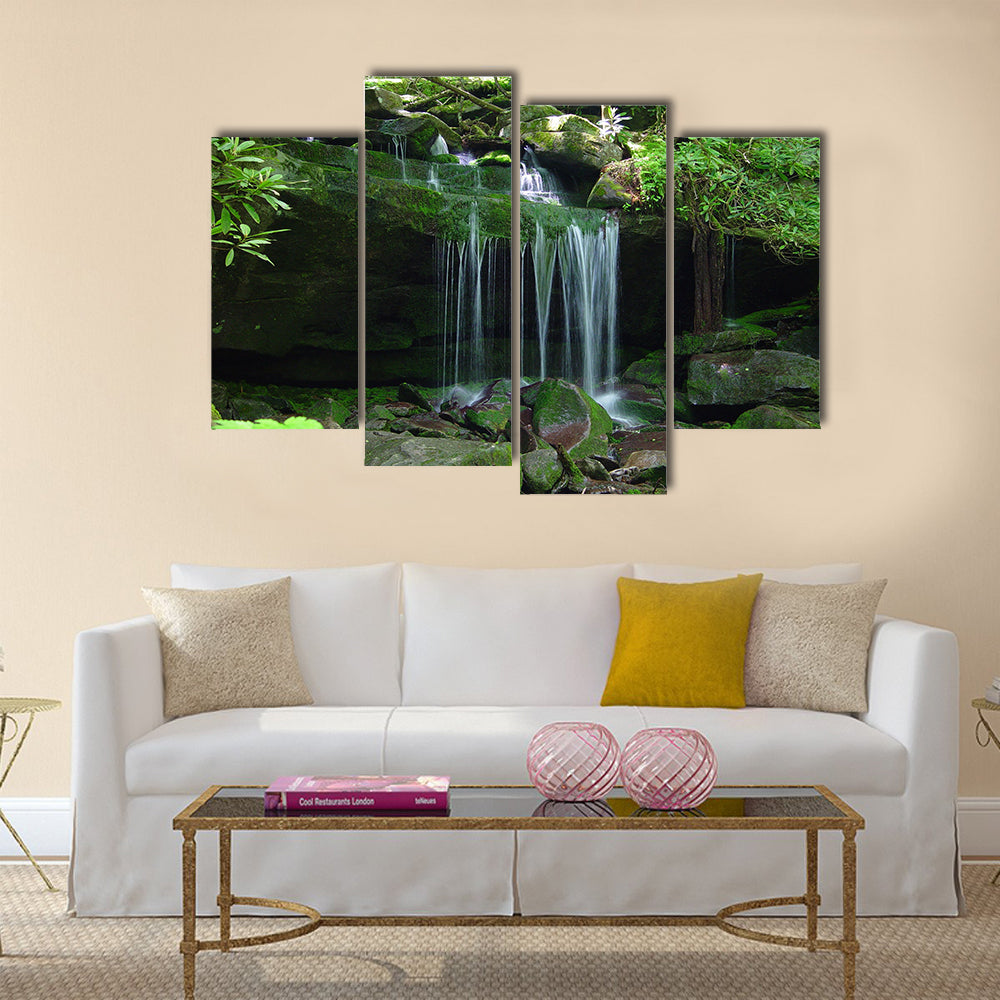 A small water fall flows on a rock ledge Multi Panel Canvas Wall Art