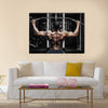 Athlete muscular bodybuilder training back on simulator in the gym, Multi panel canvas wall art