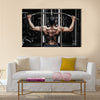 Athlete muscular bodybuilder training back on simulator in the gym, Multi panel canvas wall art