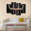 Athlete muscular bodybuilder training back on simulator in the gym, Multi panel canvas wall art