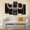 Athlete muscular bodybuilder training back on simulator in the gym, Multi panel canvas wall art