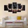 Athlete muscular bodybuilder training back on simulator in the gym, Multi panel canvas wall art