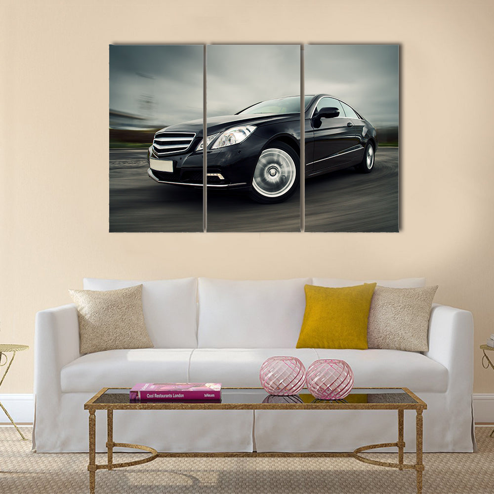 Front view of black luxury coupe driving fast Multi panel canvas wall art