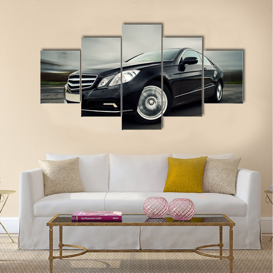 Front view of black luxury coupe driving fast Multi panel canvas wall art