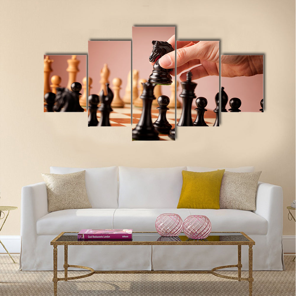 Male hand moving the black chess knight multi panel canvas wall art