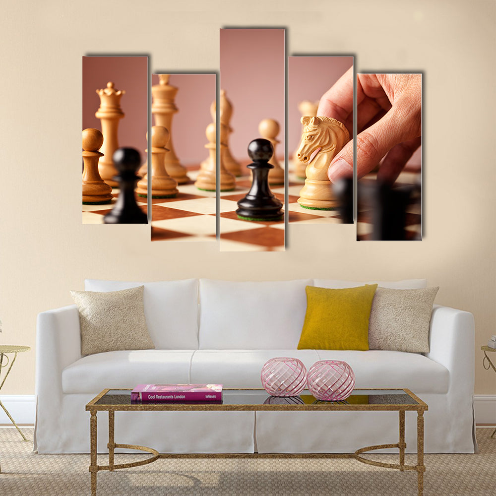 Male hand moving the white chess knight multi panel canvas wall art