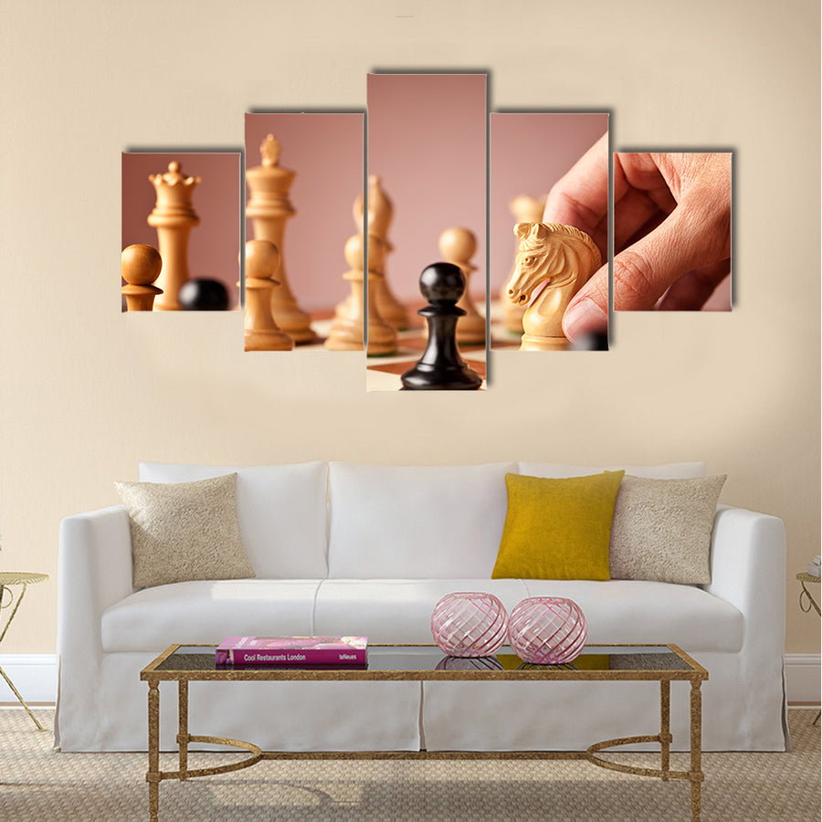Male hand moving the white chess knight multi panel canvas wall art