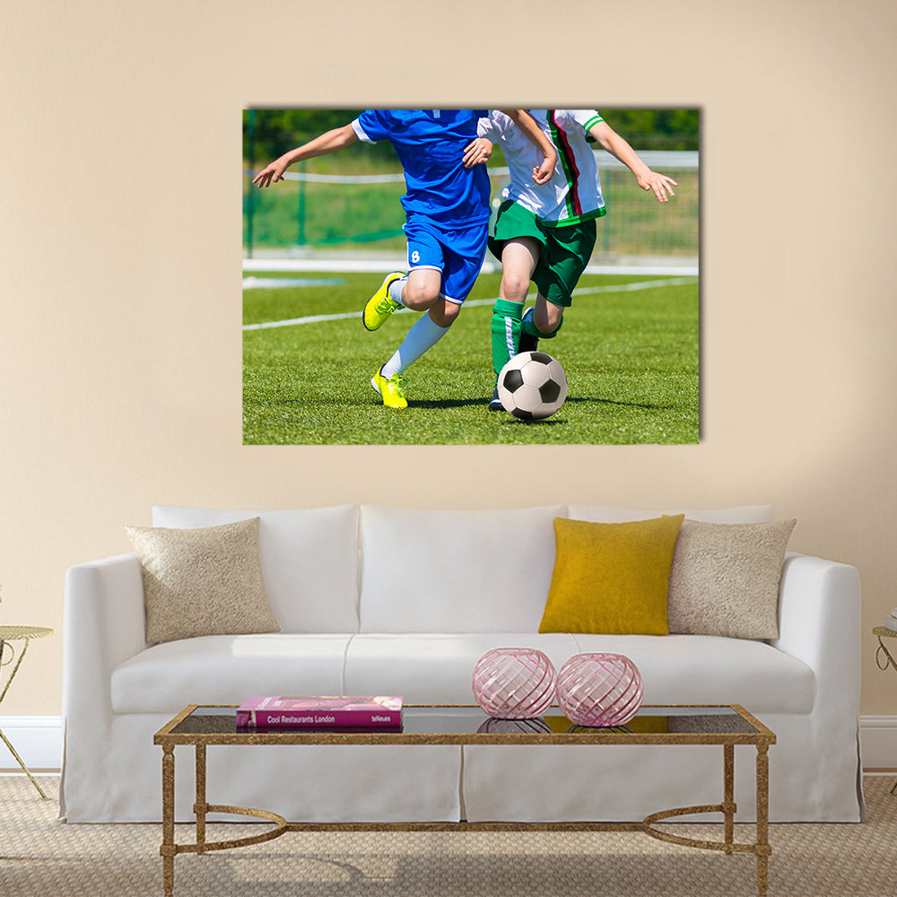 Young boys playing football soccer game running players in blue and white uniforms Multi panel canvas wall art