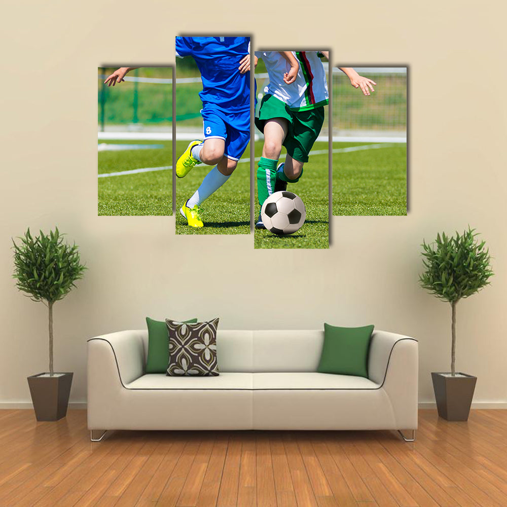 Young boys playing football soccer game running players in blue and white uniforms Multi panel canvas wall art