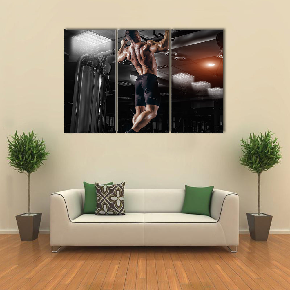 Muscle athlete man in gym making elevations Multi panel canvas wall art