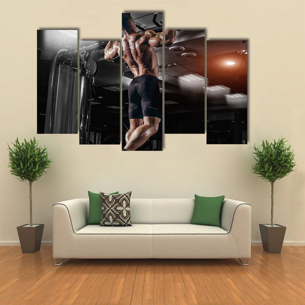 Muscle athlete man in gym making elevations Multi panel canvas wall art
