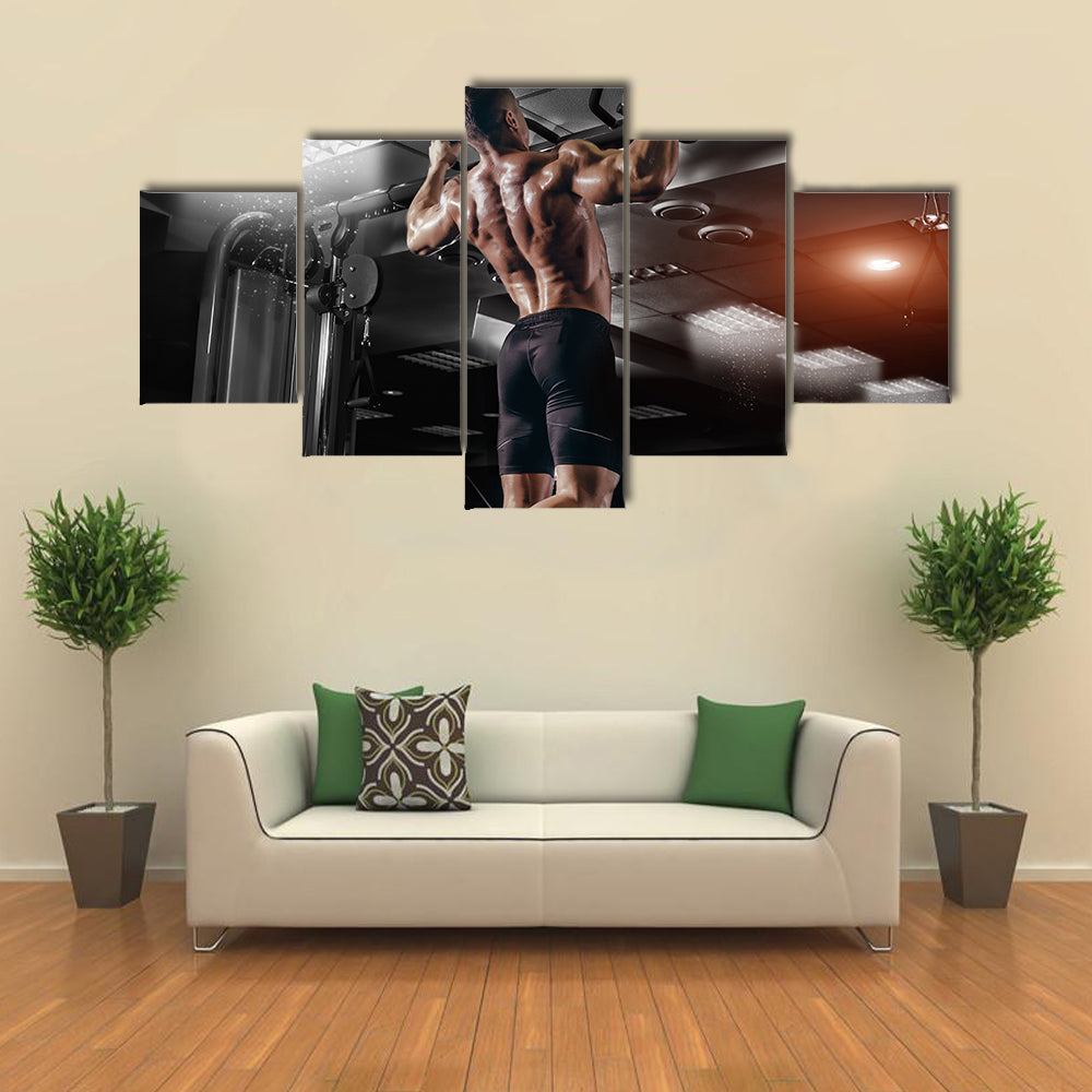 Muscle athlete man in gym making elevations Multi panel canvas wall art