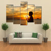 A Boy Praying With Deep Attention On A Beach In Front Of The God In The Evening Multi Panel Canvas Wall Art