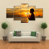 A Boy Praying With Deep Attention On A Beach In Front Of The God In The Evening Multi Panel Canvas Wall Art