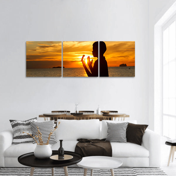 boy praying at sunset on the beach Panoramic Canvas Wall Art