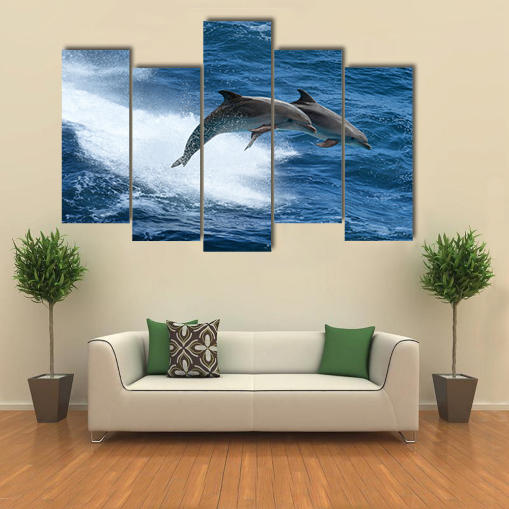 Wild nature background - two jumping dolphins in stormy sea Multi Panel Canvas Wall Art