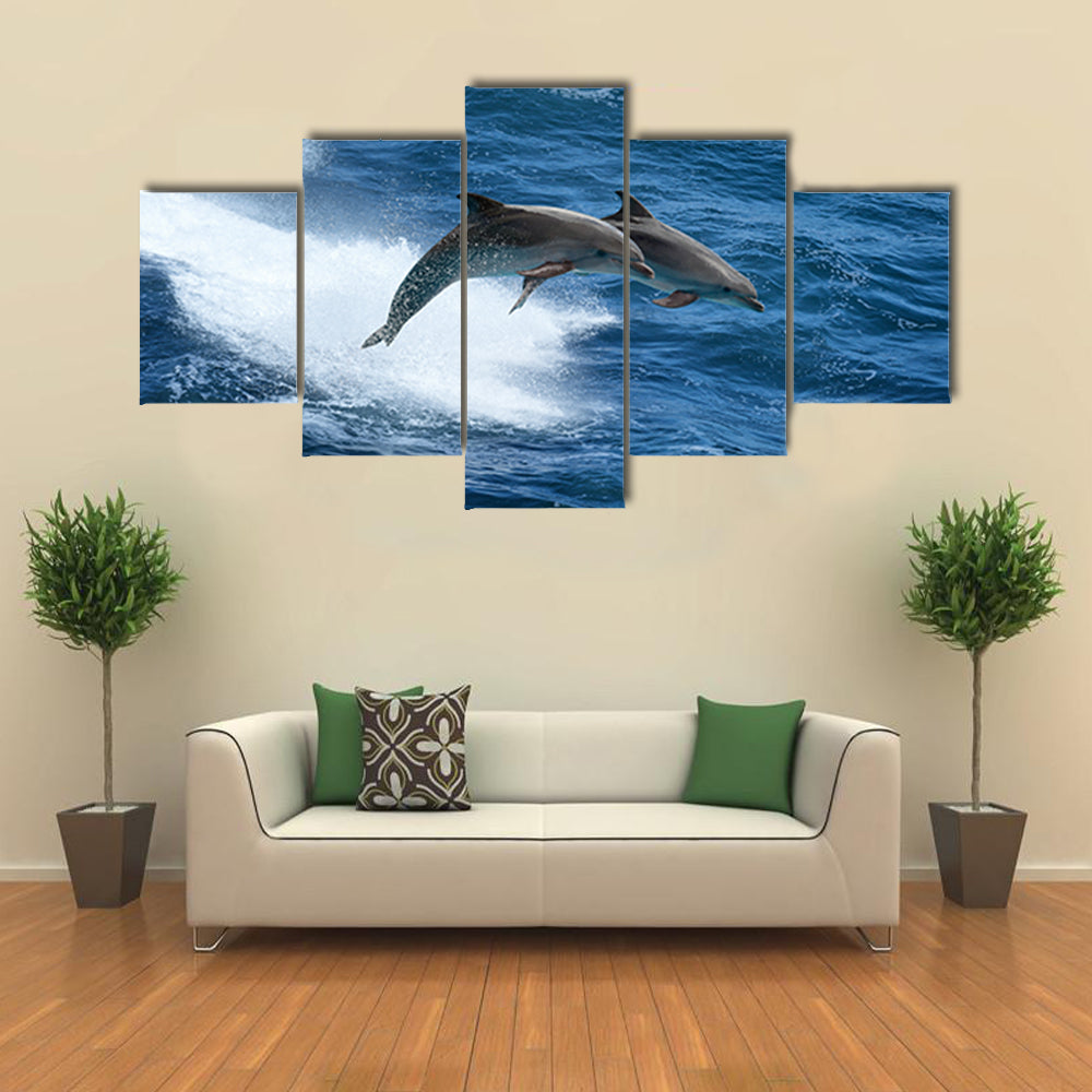Wild nature background - two jumping dolphins in stormy sea Multi Panel Canvas Wall Art