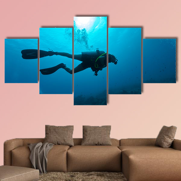 Young female scuba diver silhouette swimming underwater Multi panel canvas wall art