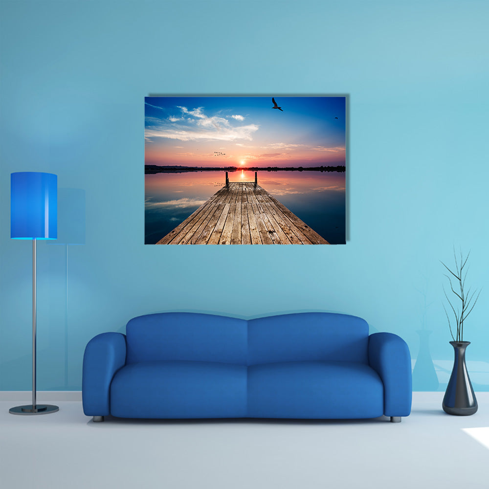 Perspective view of a wooden pier on the pond at sunset with perfectly specular reflection multi panel canvas wall art