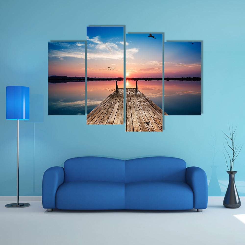 Perspective view of a wooden pier on the pond at sunset with perfectly specular reflection multi panel canvas wall art