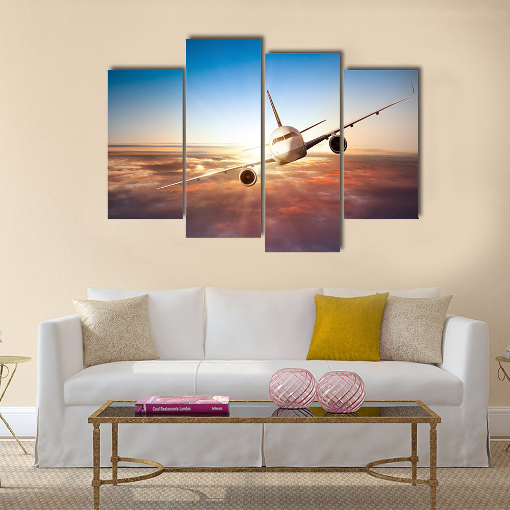 Commercial airplane flying above clouds in dramatic sunset light multi panel canvas wall art