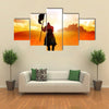 Silhouette of a medieval knight on horse carrying a flag Multi panel canvas wall art