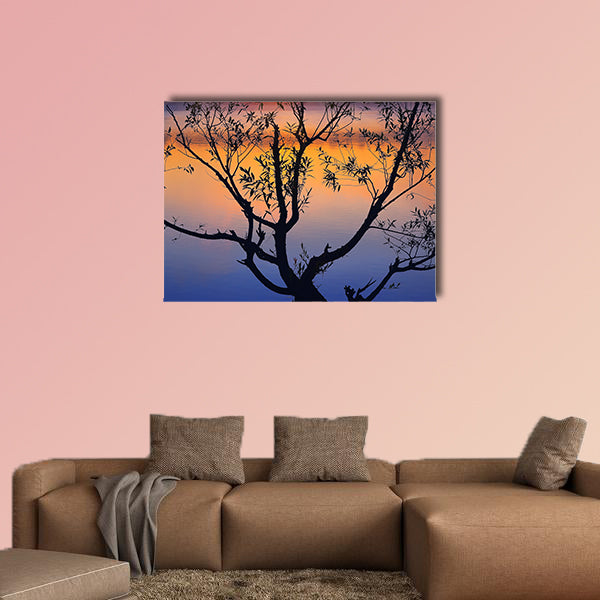 Silhouette of lonely tree growing in a pond at sunrise wall art