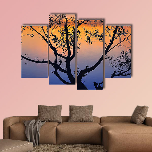 Silhouette of lonely tree growing in a pond at sunrise wall art
