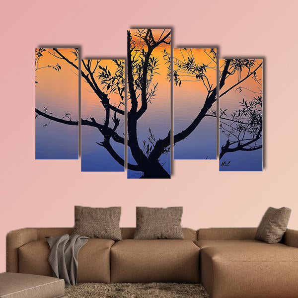 Silhouette of lonely tree growing in a pond at sunrise wall art