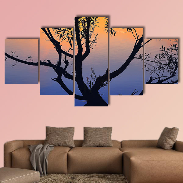 Silhouette of lonely tree growing in a pond at sunrise wall art
