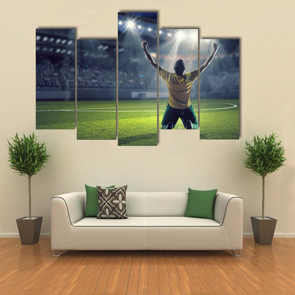 Soccer player celebrating victory while holding win cup Multi panel canvas wall art