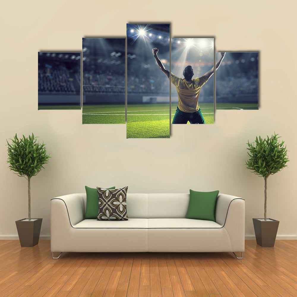 Soccer player celebrating victory while holding win cup Multi panel canvas wall art