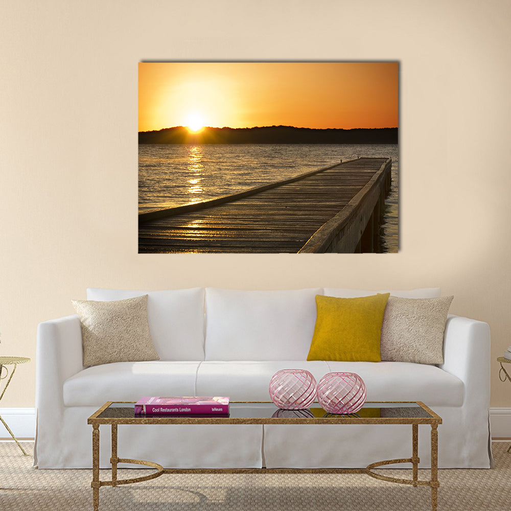A small jetty sticks out onto the lake at sunrise multi panel canvas wall art