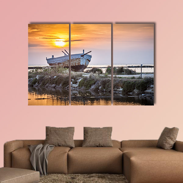 An old and weathered boat at the Sicilian sunset multi panel canvas wall art