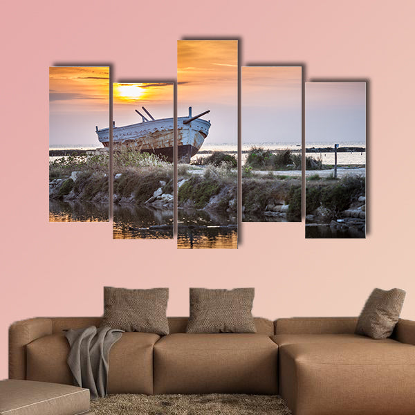 An old and weathered boat at the Sicilian sunset multi panel canvas wall art