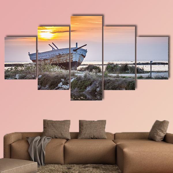 An old and weathered boat at the Sicilian sunset multi panel canvas wall art