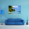 Green palms on a white sand beach with blue sky Multi panel canvas wall art