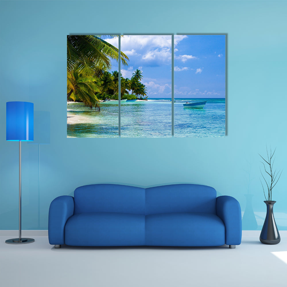 Green palms on a white sand beach with blue sky Multi panel canvas wall art