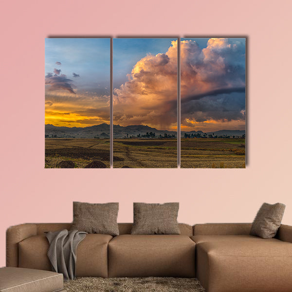 A rural landscape with stormy clouds emerging out of the mountains wall art