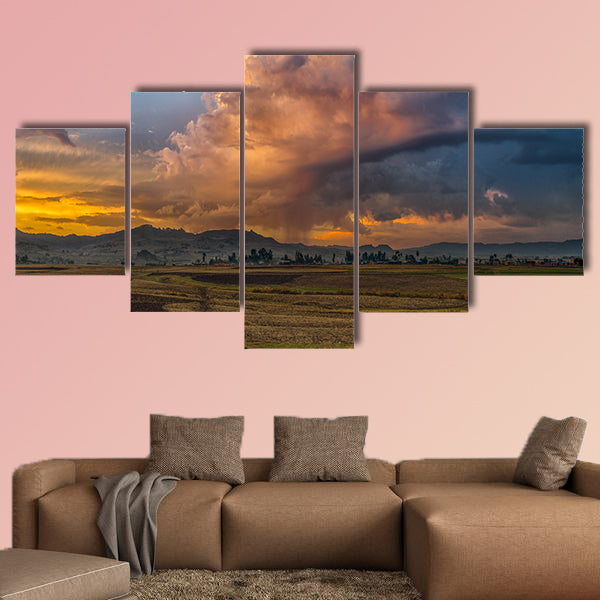 A rural landscape with stormy clouds emerging out of the mountains wall art