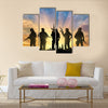 Armed terrorists near the city at sunset Multi Panel Canvas Wall Art