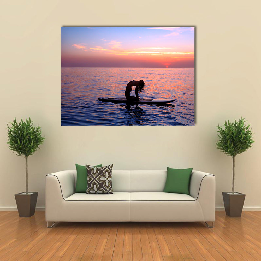 Silhouette of a yoga trainer balancing on the water on the paddle board over beautiful purple sunset Multi panel canvas wall art